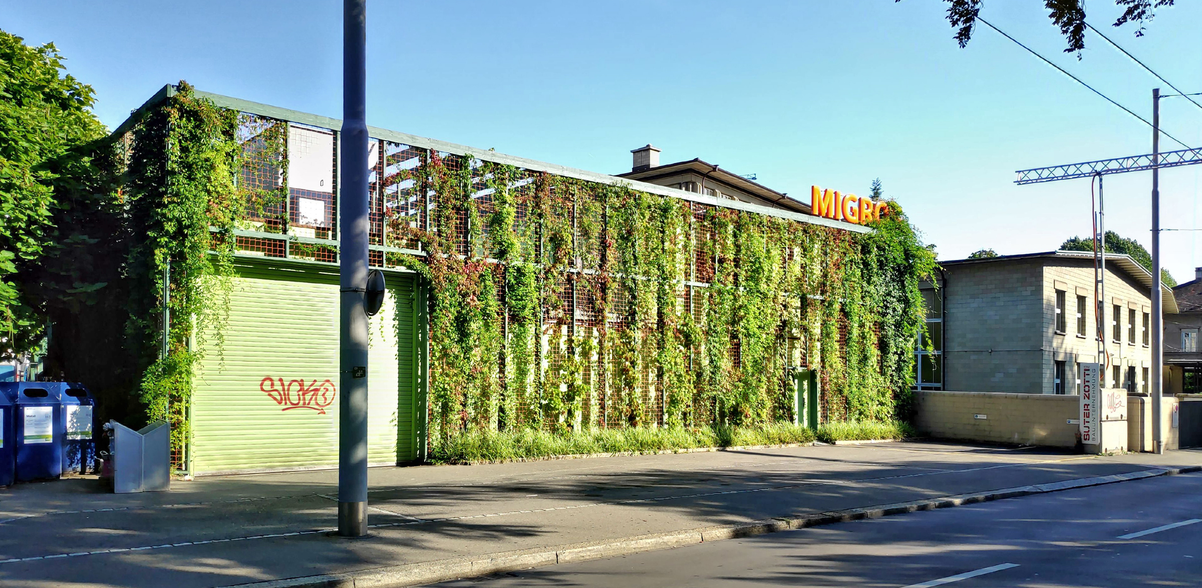 Begrünte Fassade kühlt die warme Luft des Strassenraums (Provisorium Migros Kreuzplatz; Quelle: EBP, 2019)